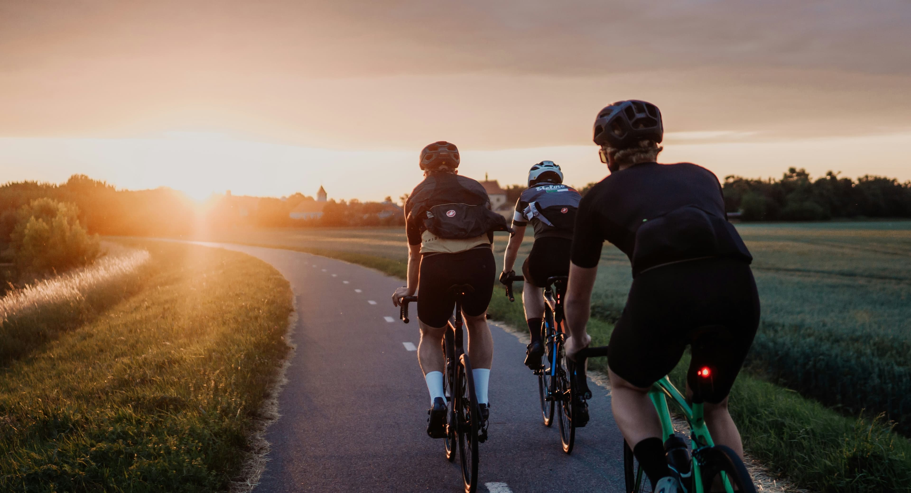 Cyclists riding into the sunset in a group