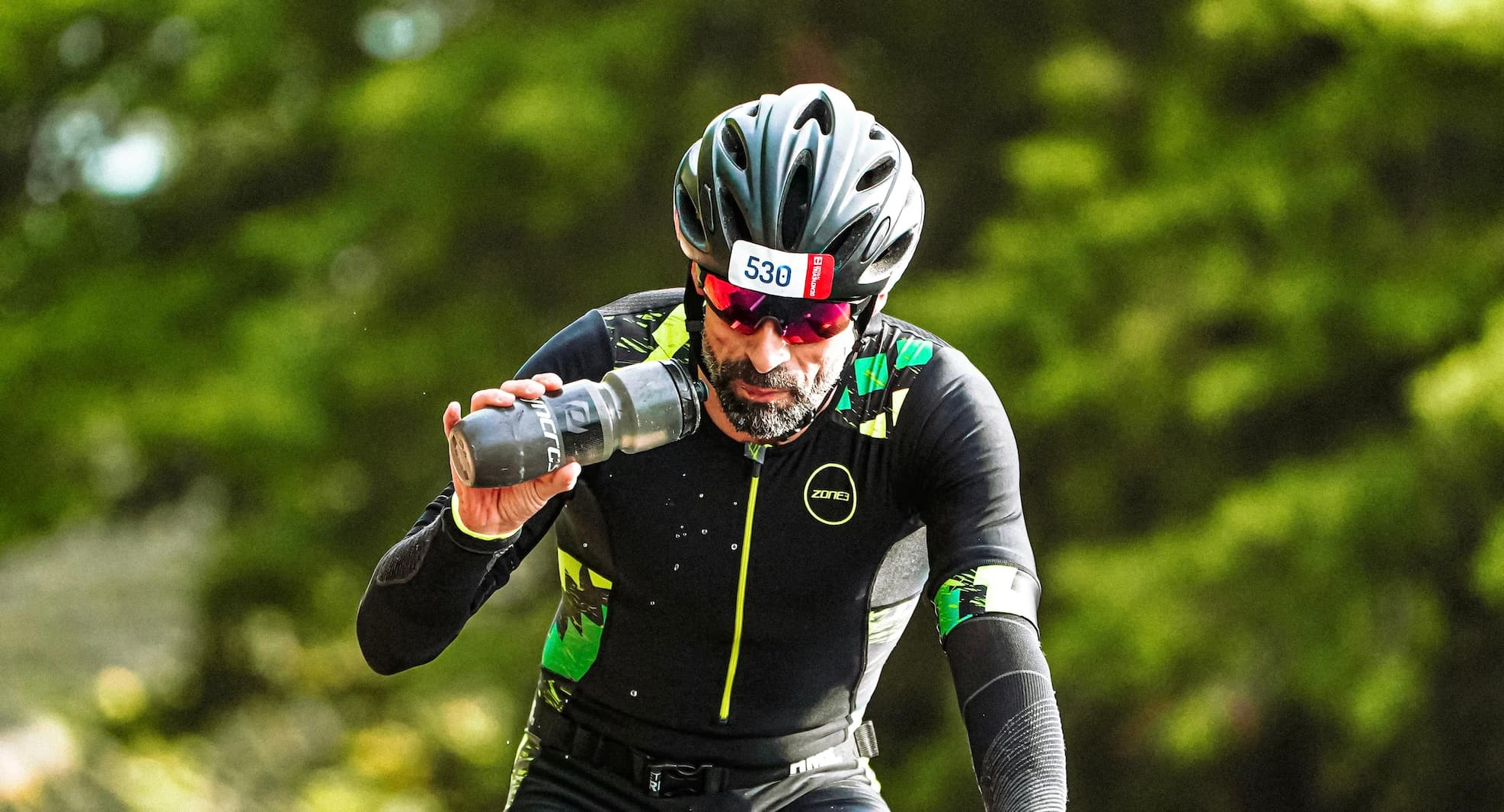 Man drinking from bottle while cycling